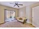 Bright bedroom with a sliding glass door, ceiling fan, and neutral carpet, and a futon couch at 5640 E Bell Rd # 1034, Scottsdale, AZ 85254