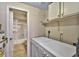 Functional laundry room includes washer, dryer, storage cabinets, and a view into the bath area at 5640 E Bell Rd # 1034, Scottsdale, AZ 85254