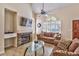 Living room features a fireplace, TV, comfortable seating, and a large arched window with shutters at 5640 E Bell Rd # 1034, Scottsdale, AZ 85254