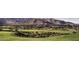 Scenic aerial view of a golf course community, lush green fairways, and mountain backdrop at 6190 N Sunrise Ln, Buckeye, AZ 85396