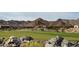 Picturesque golf course home features stunning mountain views, lush green fairways, and natural landscaping at 6190 N Sunrise Ln, Buckeye, AZ 85396