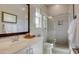 Bright bathroom with a large mirror, glass shower, and white counter tops at 6190 N Sunrise Ln, Buckeye, AZ 85396