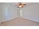 Bright bedroom featuring a ceiling fan, neutral carpet, and a doorway to another room at 6843 S 9Th Ave, Phoenix, AZ 85041