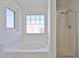 Main bathroom with tub and shower featuring a tiled backsplash and window at 6843 S 9Th Ave, Phoenix, AZ 85041
