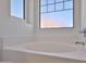 Bright main bathroom with a soaking tub and frosted windows at 6843 S 9Th Ave, Phoenix, AZ 85041