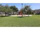 Community park with playground surrounded by green grass, trees, walking paths, and seating at 6843 S 9Th Ave, Phoenix, AZ 85041