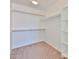 Bright walk-in closet with neutral carpet, white walls, shelves and hanging rods for easy storage at 6843 S 9Th Ave, Phoenix, AZ 85041
