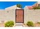 Exterior gate with address number 7802, surrounded by mature landscaping and a stucco wall at 7802 E Rovey Ave, Scottsdale, AZ 85250