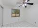 A well-lit bedroom with tile flooring, ceiling fan and view out of the window at 7802 E Rovey Ave, Scottsdale, AZ 85250