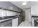 Efficient kitchen featuring gray cabinetry, subway tile backsplash, and granite counters at 7802 E Rovey Ave, Scottsdale, AZ 85250