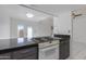 Kitchen featuring an electric stove, granite countertops, and white tile flooring at 7802 E Rovey Ave, Scottsdale, AZ 85250