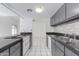 Bright kitchen featuring an electric stove, granite countertops, white tile flooring and gray cabinets at 7802 E Rovey Ave, Scottsdale, AZ 85250