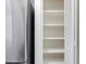 View of a pantry with white shelves adjacent to a stainless steel refrigerator at 7802 E Rovey Ave, Scottsdale, AZ 85250