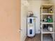 Utility room featuring a water heater and plastic shelving unit for organized storage at 7802 E Rovey Ave, Scottsdale, AZ 85250