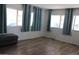 Bright living room with new wood flooring and large windows dressed with teal curtains at 7807 E Main St # D-26, Mesa, AZ 85207