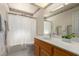 Bathroom featuring oak vanity with white countertop, framed mirror and tub shower at 7839 E Milagro Ave, Mesa, AZ 85209
