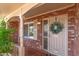 Charming front entrance with brick facade, decorative wreath, and well-kept landscaping at 7839 E Milagro Ave, Mesa, AZ 85209