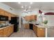 Open concept kitchen with wood cabinets, granite countertops, and black appliances at 7839 E Milagro Ave, Mesa, AZ 85209
