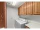 Laundry room features side-by-side washer and dryer, upper cabinets and a folding counter at 7839 E Milagro Ave, Mesa, AZ 85209