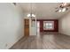 Spacious living area with stylish lighting fixtures, wood-look tile flooring, and natural light at 7839 E Milagro Ave, Mesa, AZ 85209