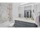 Bright bathroom featuring marble tiled shower/tub, with gray vanity and large mirror at 945 E Playa Del Norte Dr # 4019, Tempe, AZ 85288