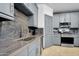 Sleek kitchen featuring gray cabinetry, stainless steel appliances, and contrasting countertops and backsplash at 945 E Playa Del Norte Dr # 4019, Tempe, AZ 85288