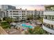 Aerial view of community pool with palm trees and barbecue areas, set against the backdrop of a multi-story building at 945 E Playa Del Norte Dr # 4019, Tempe, AZ 85288