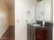 Well-lit bathroom featuring a sleek vanity with dark wood cabinets and a black granite countertop at 9708 W Redwood Dr, Sun City, AZ 85351