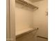 Empty closet with metal racks and shelves in a neutral colored room at 9708 W Redwood Dr, Sun City, AZ 85351