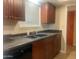 Functional kitchen features wood cabinetry, black appliances and a double sink at 9708 W Redwood Dr, Sun City, AZ 85351