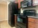 Functional kitchen features wood cabinetry, black appliances and a modern oven at 9708 W Redwood Dr, Sun City, AZ 85351
