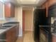 Functional kitchen features wood cabinetry, black appliances and a spacious layout at 9708 W Redwood Dr, Sun City, AZ 85351