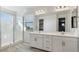 Modern bathroom featuring dual sinks, a large mirror, and a walk-in shower at 10013 E Trent Ave, Mesa, AZ 85212