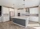 Spacious kitchen with white cabinets, center island, and modern pendant lighting at 10013 E Trent Ave, Mesa, AZ 85212