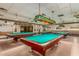 Spacious billiard room featuring multiple pool tables, comfortable seating, and decorative lighting fixtures at 11360 E Keats Ave # 92, Mesa, AZ 85209