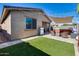 Inviting backyard with a manicured lawn, a hot tub, shade covering and stylish patio furniture at 12211 W Hide Trl, Peoria, AZ 85383