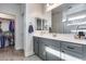 Modern bathroom with gray cabinets, walk in closet and a well-lit mirror at 12211 W Hide Trl, Peoria, AZ 85383