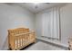 Neutral Bedroom features wood look floors, crib, and white curtains at 12211 W Hide Trl, Peoria, AZ 85383