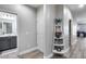 Hallway features neutral paint, wood-look floors, and storage shelves by the door at 12211 W Hide Trl, Peoria, AZ 85383