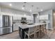 Modern kitchen with stainless steel appliances, a large center island with seating, and stylish pendant lighting at 12211 W Hide Trl, Peoria, AZ 85383