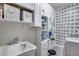 Well organized laundry room with white cabinets, utility sink, and patterned wallpaper at 12211 W Hide Trl, Peoria, AZ 85383