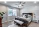 Bright main bedroom with a king bed, bench, and natural light from the window at 12211 W Hide Trl, Peoria, AZ 85383