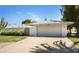 Home exterior featuring a two-car garage, a desert landscaped yard, and a decorative gate at 12826 W Maplewood Dr, Sun City West, AZ 85375