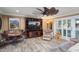 Cozy living room with a decorative ceiling fan, wood-look tile floors, and built-in shelving at 12826 W Maplewood Dr, Sun City West, AZ 85375