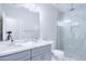 Bright bathroom featuring dual vanity sinks, a toilet, and glass shower stall at 12938 W Tara Ln, Surprise, AZ 85374