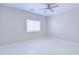 Neutrally decorated bedroom with tile floors, modern fan, and window with blinds at 12938 W Tara Ln, Surprise, AZ 85374