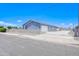 Charming single-story home featuring a blue stucco exterior and white gated entrance for added security at 12938 W Tara Ln, Surprise, AZ 85374