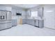 Modern kitchen features stainless steel appliances, grey cabinets, quartz countertops, and a stylish tile floor at 12938 W Tara Ln, Surprise, AZ 85374