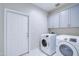 Laundry room featuring a washer and dryer, storage cabinets, and tile floors at 12938 W Tara Ln, Surprise, AZ 85374