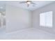 Neutral bedroom featuring tiled floors, a large window, and access to the hallway at 12940 W Tara Ln, Surprise, AZ 85374